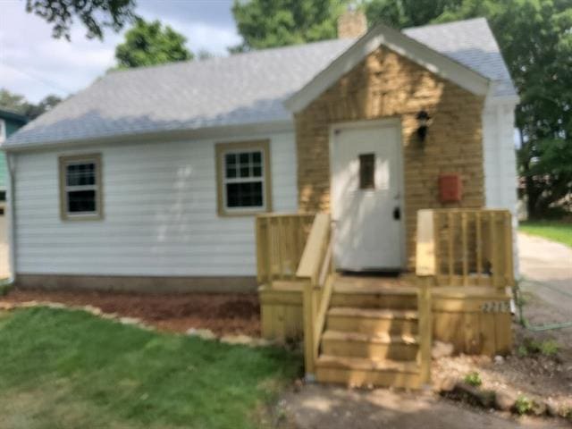 view of front of property with stone siding and a chimney