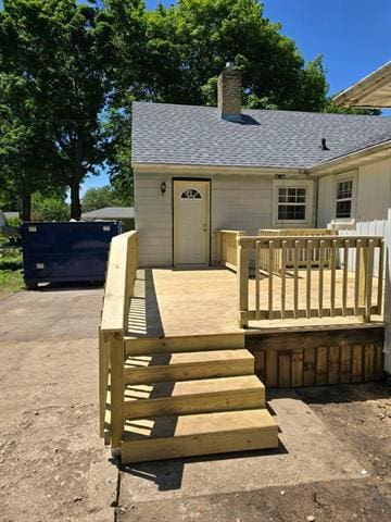 wooden terrace featuring concrete driveway