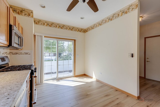 kitchen with backsplash, stainless steel appliances, ceiling fan, and light wood-type flooring