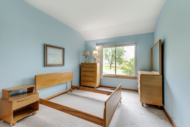 carpeted bedroom featuring baseboards and lofted ceiling