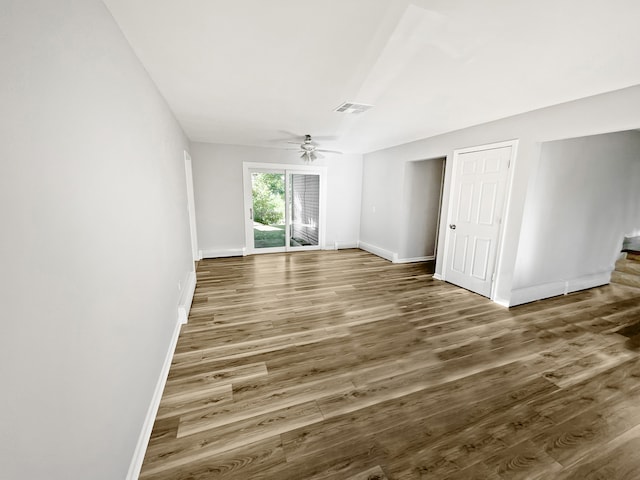 empty room featuring dark wood-type flooring and ceiling fan