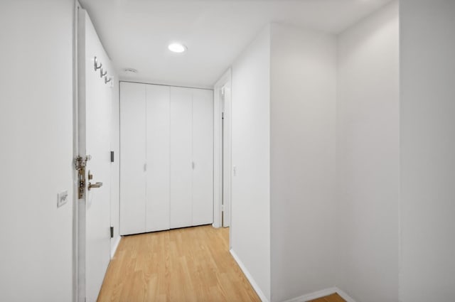 corridor with recessed lighting, light wood-type flooring, and baseboards