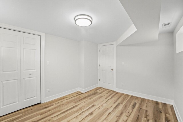 unfurnished bedroom featuring light hardwood / wood-style flooring and a closet