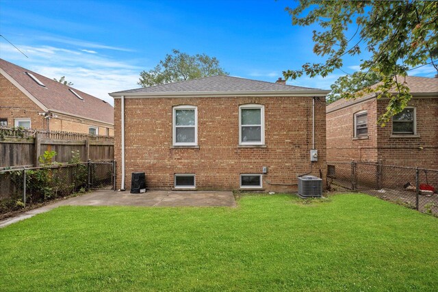 rear view of property featuring a yard, a patio area, and central air condition unit