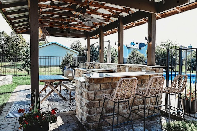 view of patio / terrace featuring ceiling fan and exterior bar