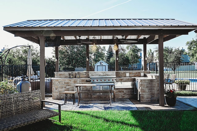 view of patio / terrace featuring a gazebo, grilling area, a bar, and an outdoor kitchen