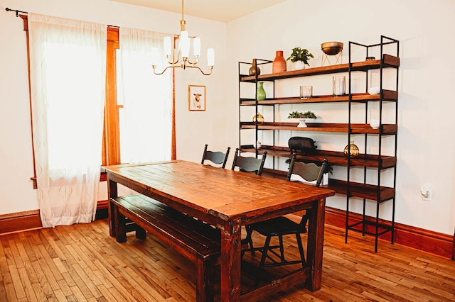 dining area with an inviting chandelier and hardwood / wood-style flooring