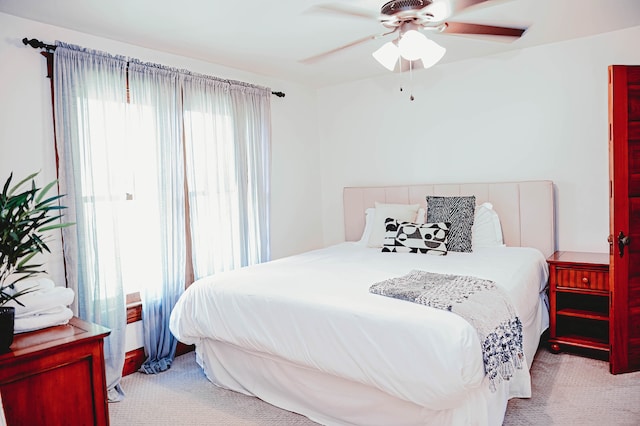 carpeted bedroom with ceiling fan and multiple windows