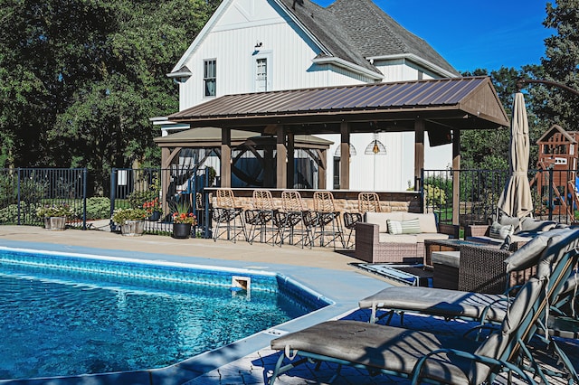 view of pool with a patio and an outdoor bar