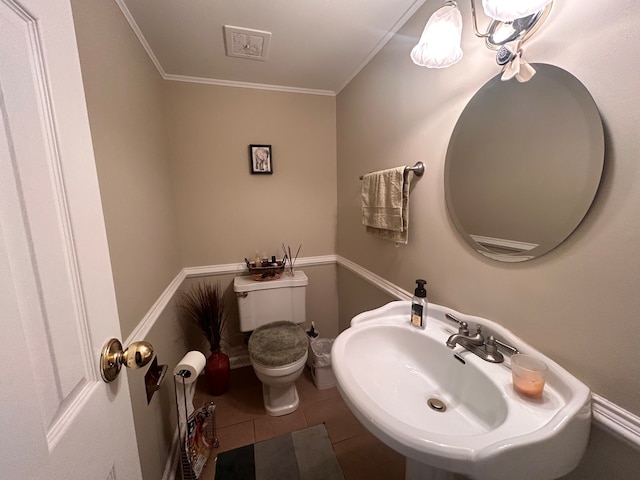 bathroom with ornamental molding, sink, toilet, and tile patterned floors