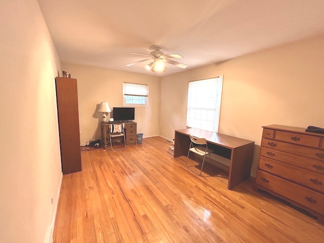 office with light hardwood / wood-style flooring and ceiling fan