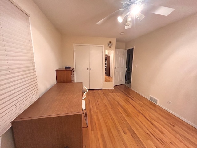 unfurnished bedroom with light hardwood / wood-style floors, ceiling fan, and a closet