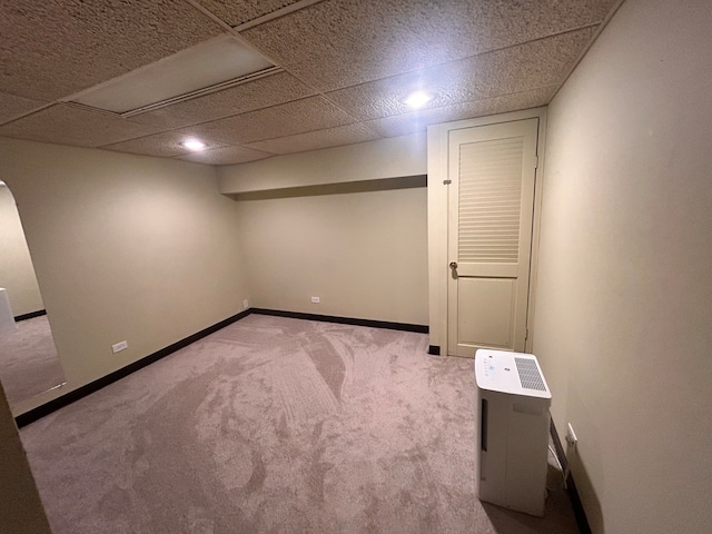 basement with light carpet and a drop ceiling