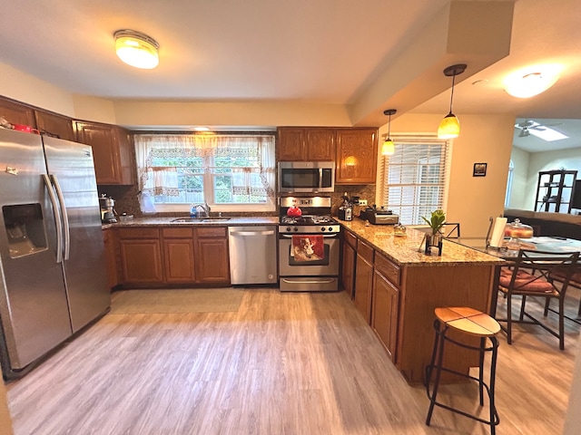 kitchen featuring decorative backsplash, kitchen peninsula, appliances with stainless steel finishes, and decorative light fixtures