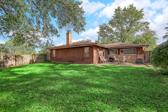 back of house featuring cooling unit, a yard, and a patio