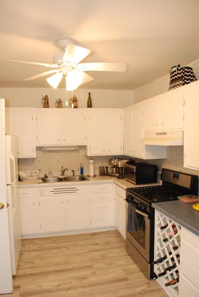 kitchen featuring sink, white cabinets, tasteful backsplash, light hardwood / wood-style flooring, and appliances with stainless steel finishes