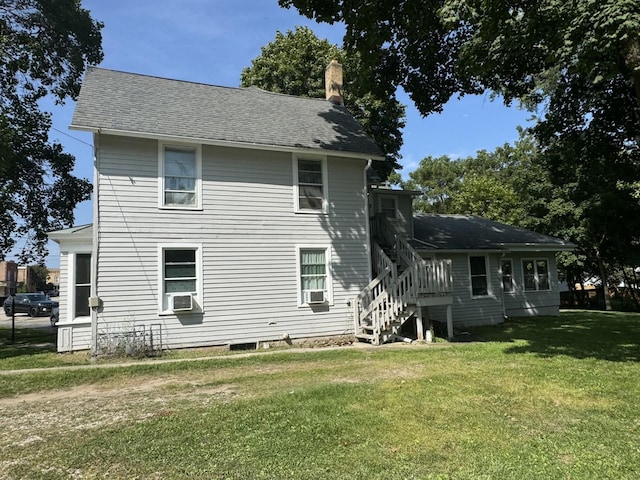 back of property featuring cooling unit and a yard