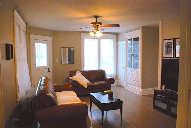 living room featuring ceiling fan and hardwood / wood-style flooring