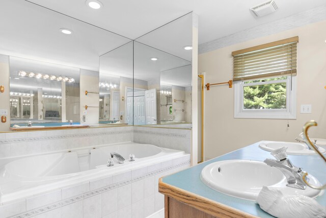 bathroom featuring vanity and tiled bath