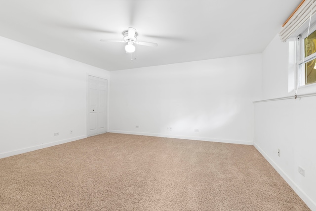 spare room with ceiling fan and light colored carpet