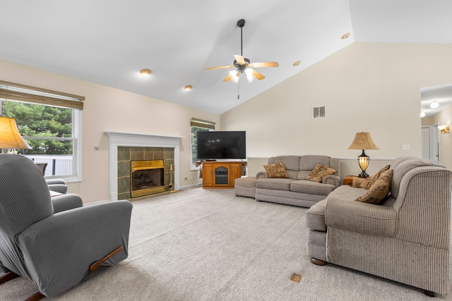 living room featuring a fireplace, ceiling fan, high vaulted ceiling, and light carpet