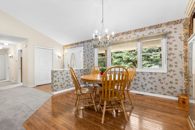 dining space with lofted ceiling, carpet, a notable chandelier, and a healthy amount of sunlight