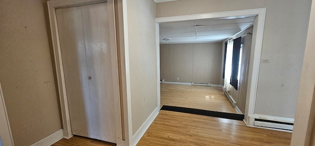 hallway featuring light wood-type flooring and baseboard heating