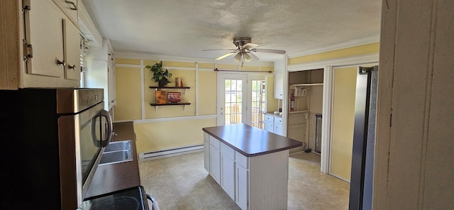 kitchen with ceiling fan, baseboard heating, light tile patterned floors, a textured ceiling, and a center island