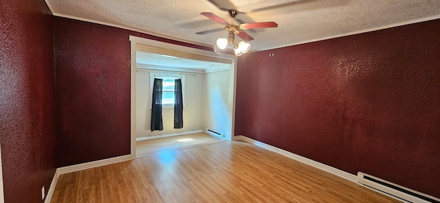 unfurnished room featuring light hardwood / wood-style floors, a baseboard heating unit, ornamental molding, and ceiling fan