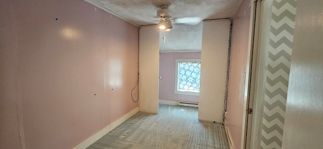 corridor with a baseboard heating unit, a textured ceiling, and light carpet