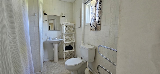 bathroom with a shower with shower curtain, tile patterned flooring, sink, tile walls, and toilet