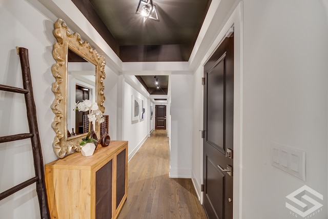 hall with a tray ceiling and hardwood / wood-style flooring