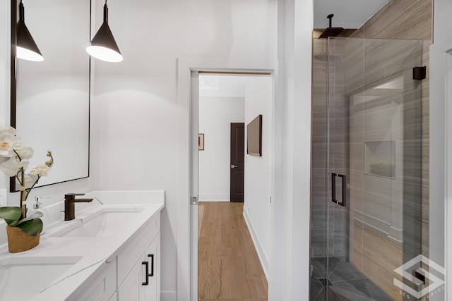 bathroom with vanity, an enclosed shower, and wood-type flooring