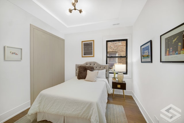 bedroom featuring dark hardwood / wood-style floors and a chandelier