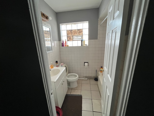 bathroom with toilet, tile walls, tile patterned floors, and vanity