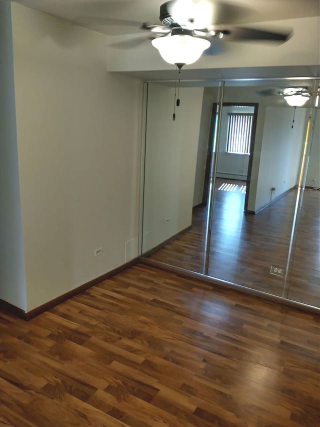 unfurnished bedroom featuring ceiling fan and dark hardwood / wood-style floors