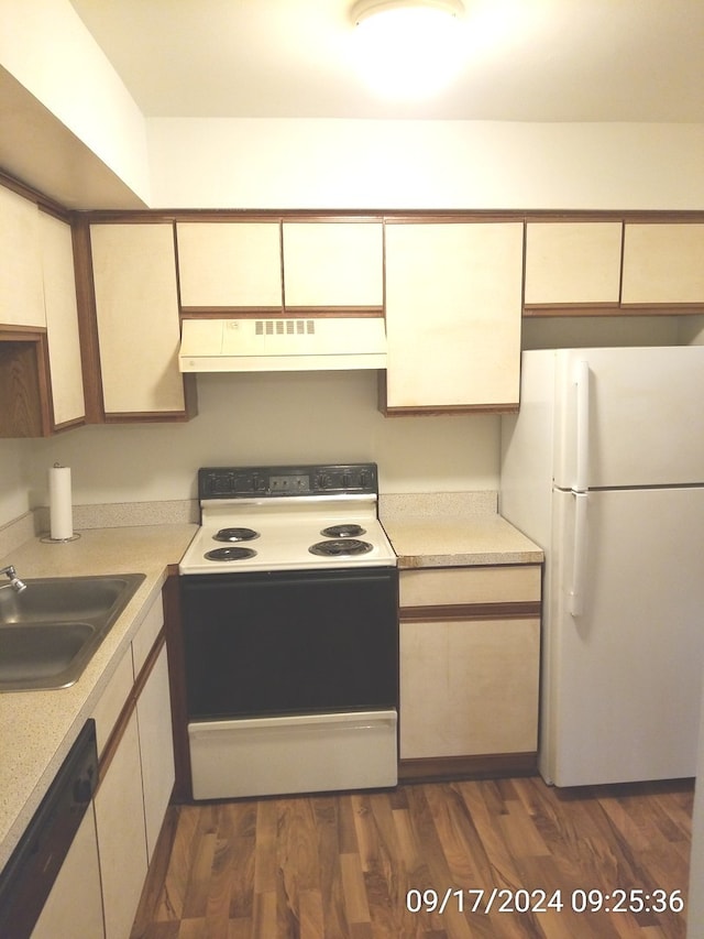 kitchen featuring white appliances, sink, and dark wood-type flooring