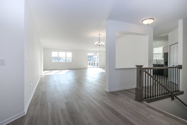 hallway with hardwood / wood-style flooring and an inviting chandelier