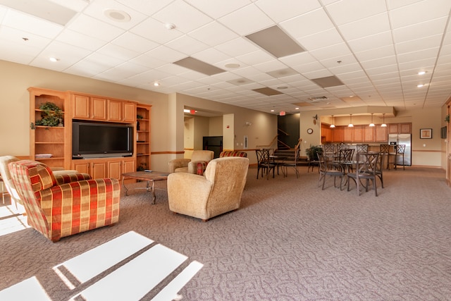 living room featuring light colored carpet and a drop ceiling