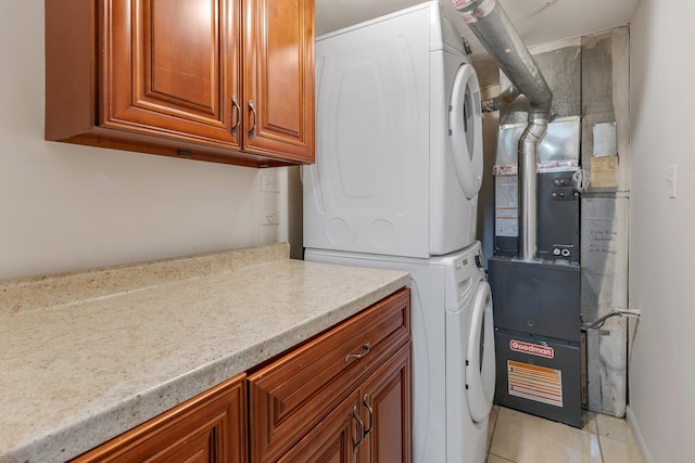 1781 Queensbury Cir, Hoffman Estates, IL 60169 - laundry room featuring stacked washer / drying machine, cabinet space, and light tile patterned floors