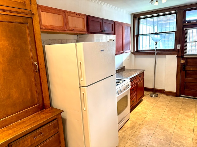 kitchen featuring crown molding, white appliances, and light tile patterned floors