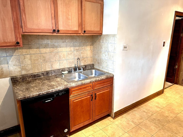 kitchen with black dishwasher, backsplash, brown cabinetry, a sink, and baseboards