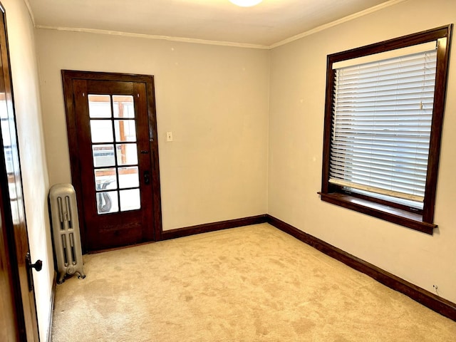 empty room featuring baseboards, ornamental molding, light colored carpet, and radiator