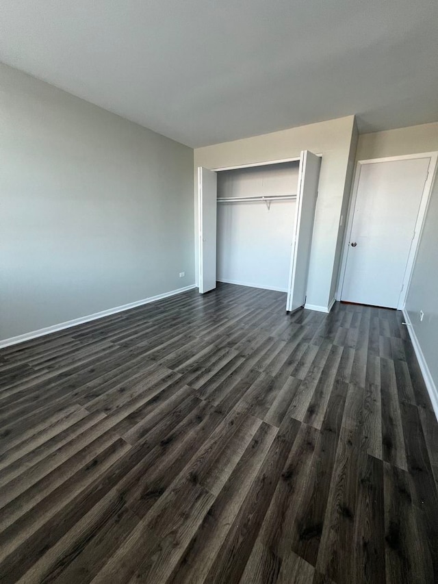 unfurnished bedroom featuring dark wood-type flooring and a closet