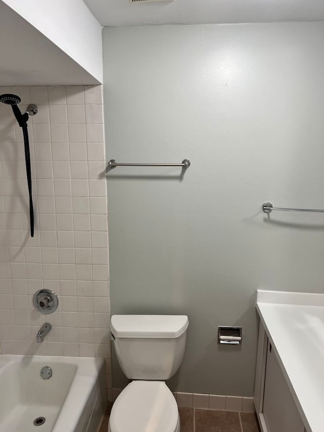 full bathroom featuring tile patterned flooring, vanity, tiled shower / bath combo, and toilet