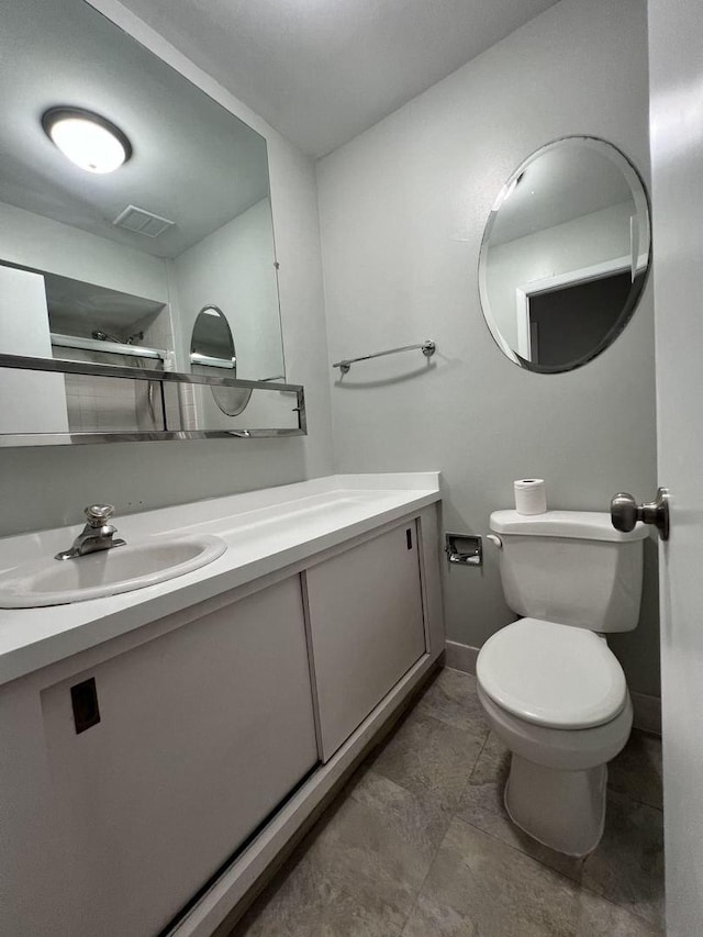 bathroom with toilet, baseboards, and vanity