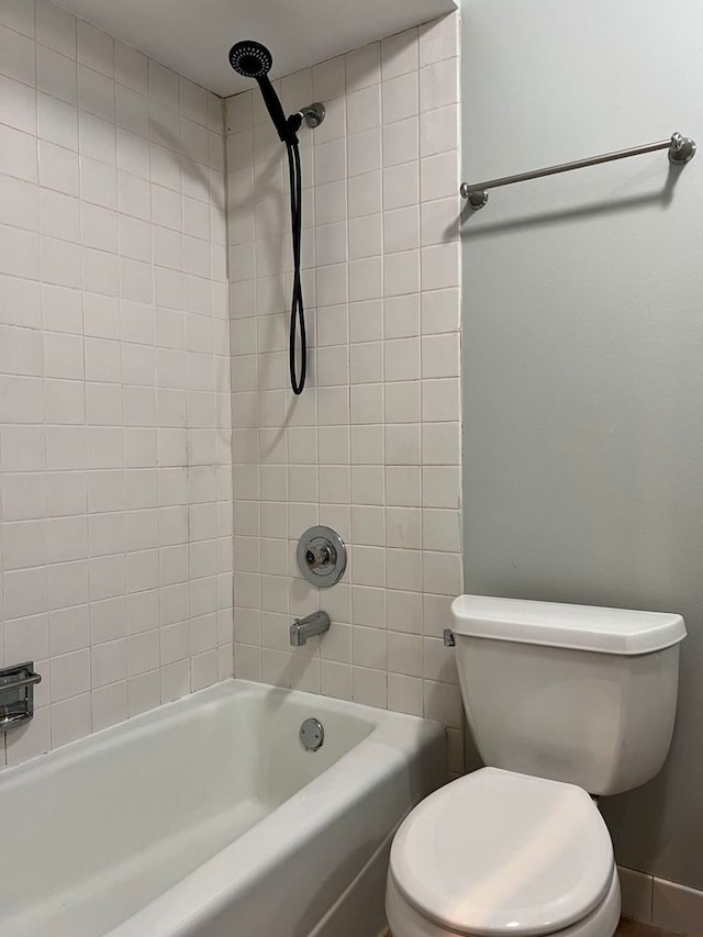 bathroom with tiled shower / bath and toilet