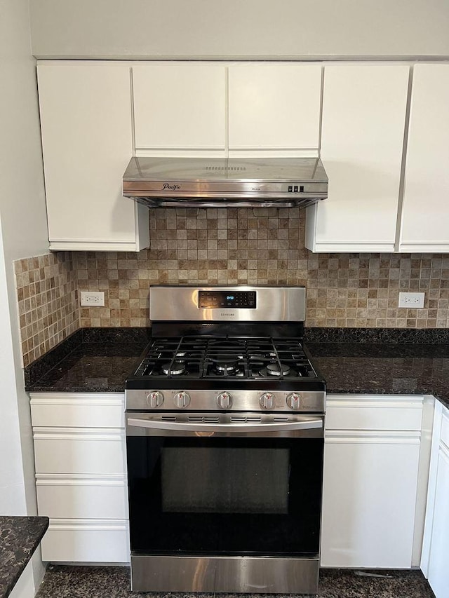 kitchen with decorative backsplash, dark stone counters, stainless steel gas range, ventilation hood, and white cabinetry