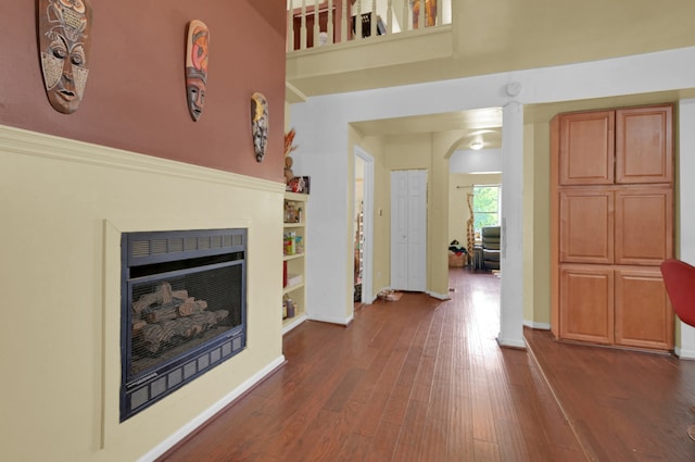 interior space featuring built in shelves and dark hardwood / wood-style floors