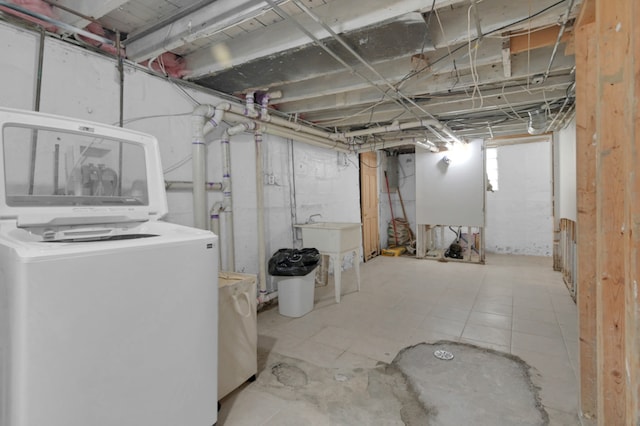 basement featuring washer / dryer and light tile patterned flooring